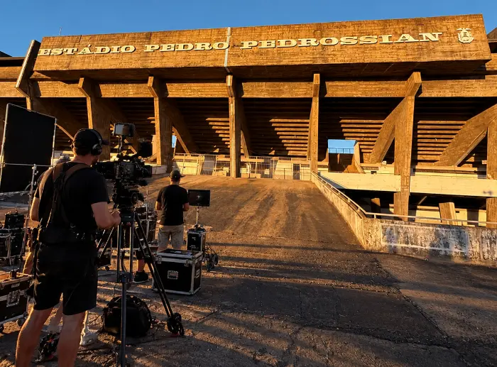 The crew filming outside Estádio Pedro Pedrossian at sunset